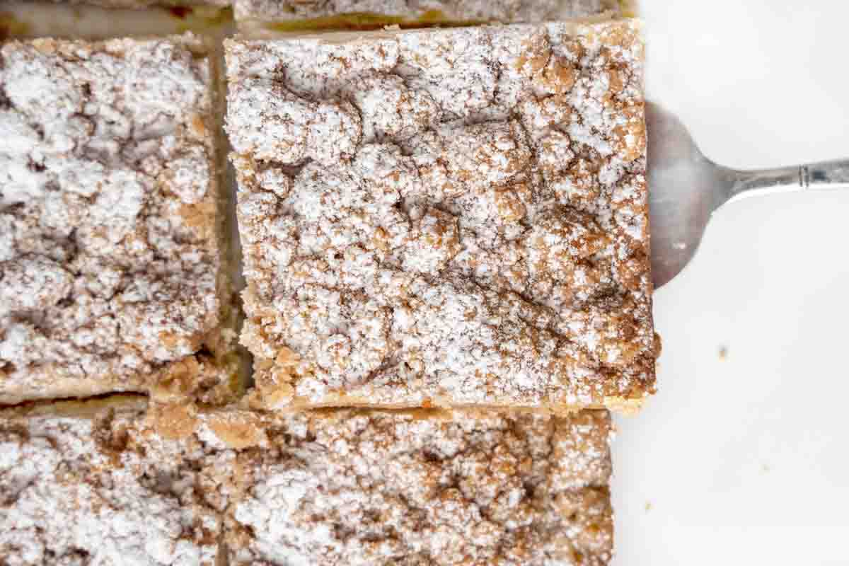 Section of whole crumb cake sliced with spatula under one piece.