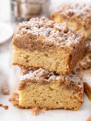 Two slices of crumb cake stacked on a white plate.