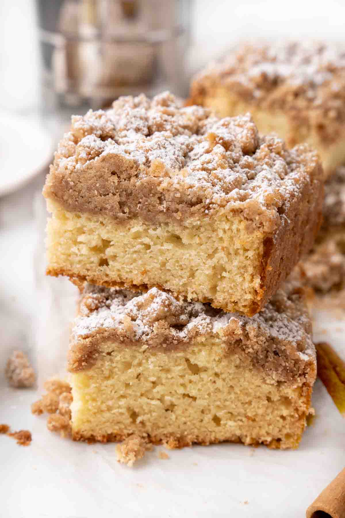 Two slices of crumb cake stacked on a white plate.