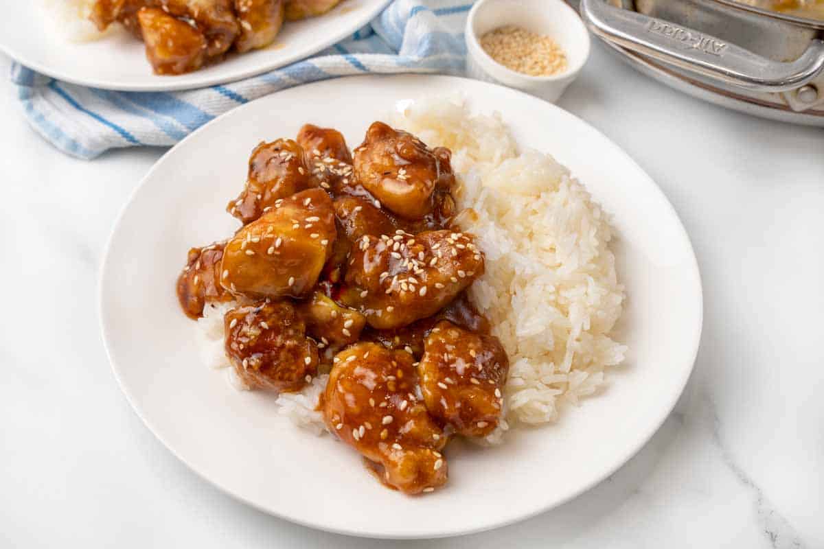 General Tso's chicken with white rice on a white plate.