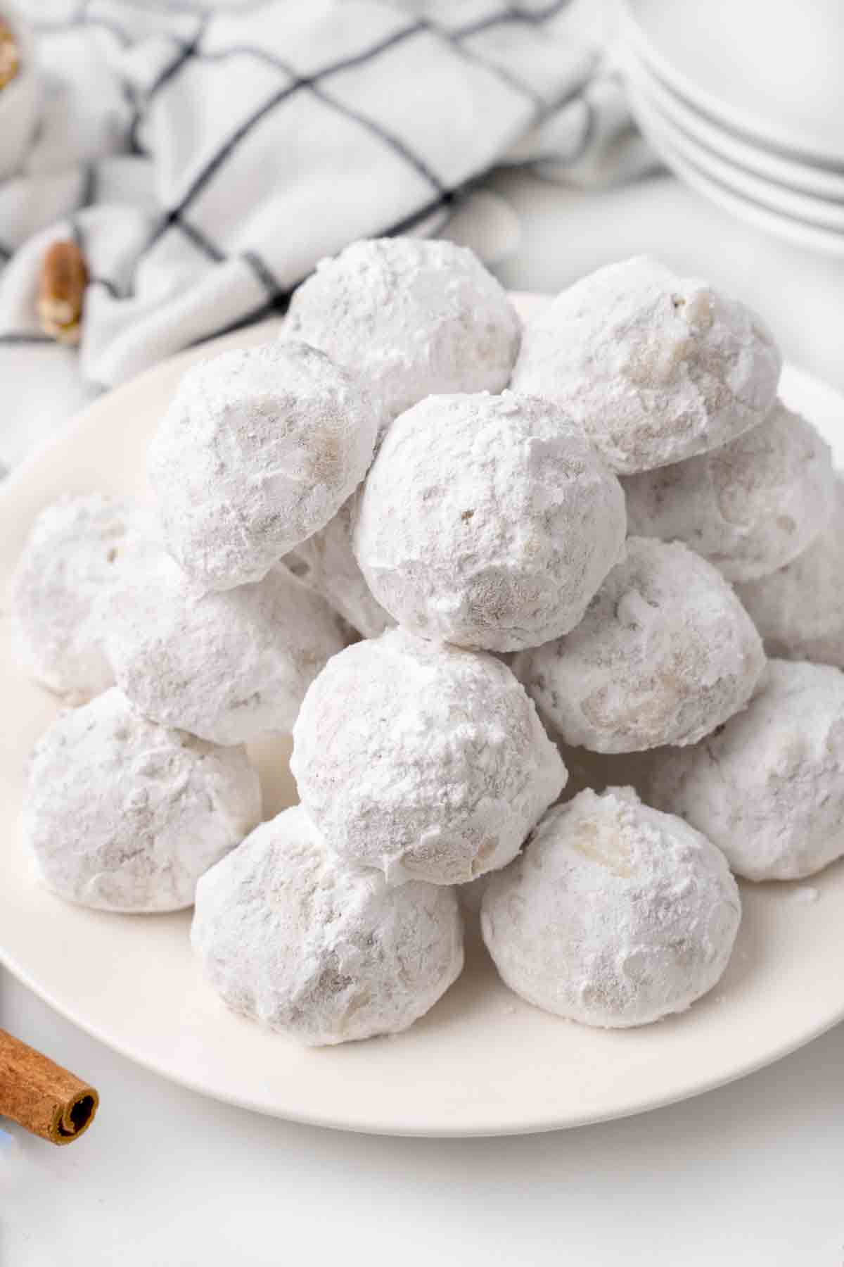 Mexican wedding cookies stacked on a white platter.