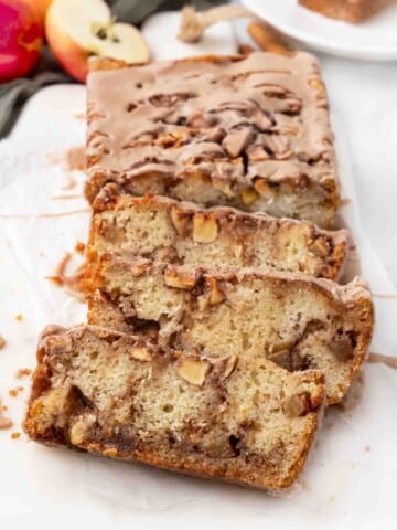 Slices of apple fritter bread on a white cutting board.