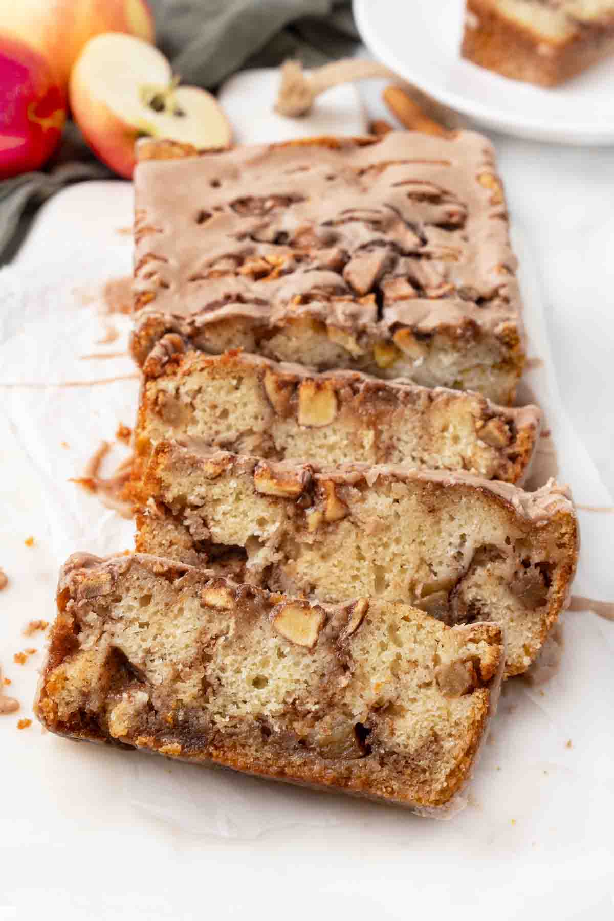 Slices of apple fritter bread on a white cutting board.