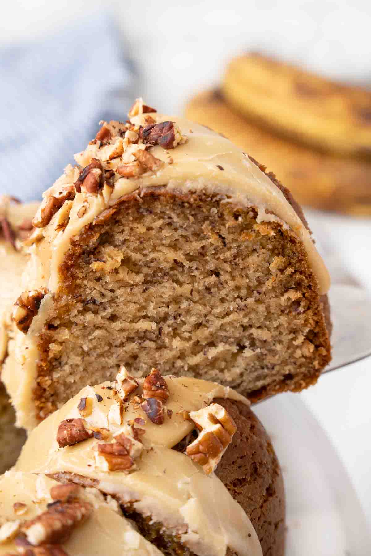 Slice of banana bundt cake being taken out of the cake.