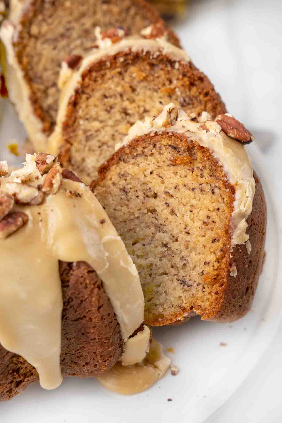 Banana bundt cake sliced on a white platter.