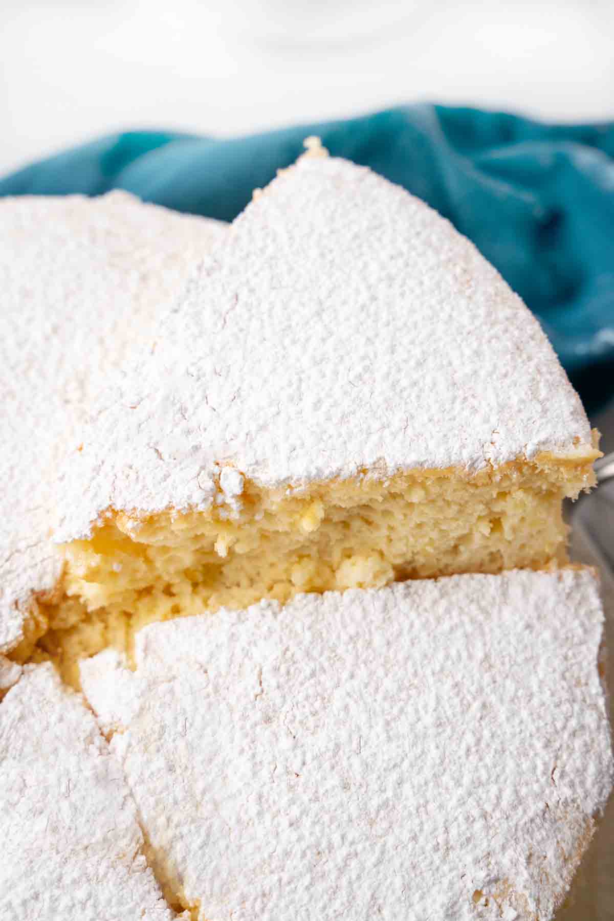 Slice of Japanese cheesecake being taken out of the whole cake.