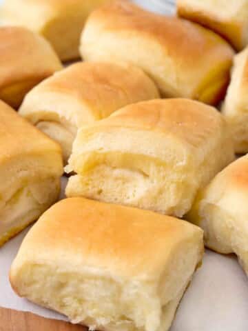 Parker house rolls on a white parchment paper.