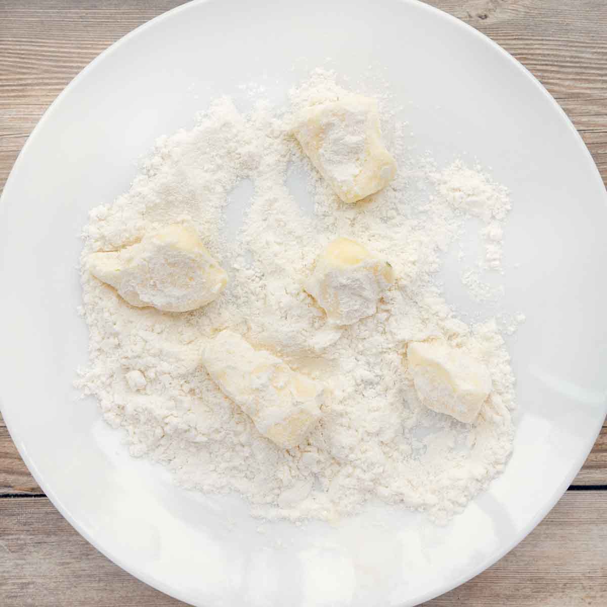 butter rolled in flour on a white plate.