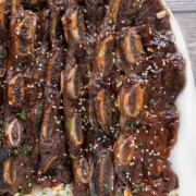 Korean beef short ribs with rice on a white platter.