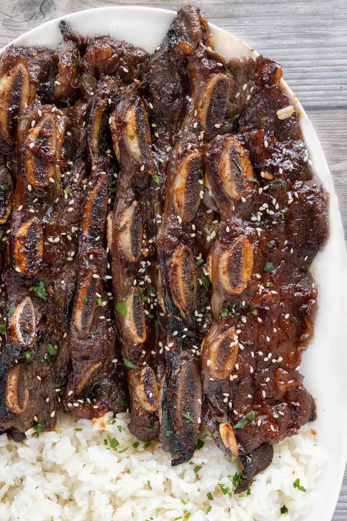 Korean beef short ribs with rice on a white platter.