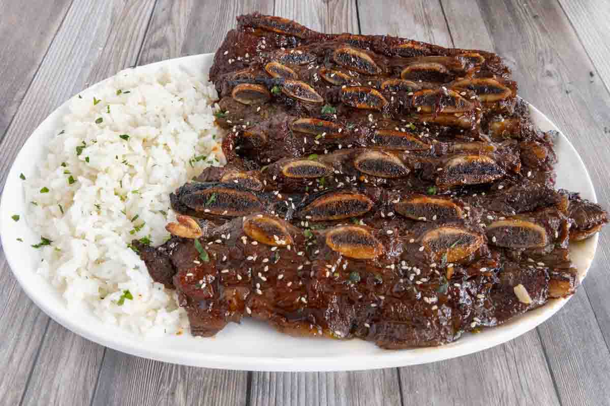 orean beef short ribs with rice on a white platter.