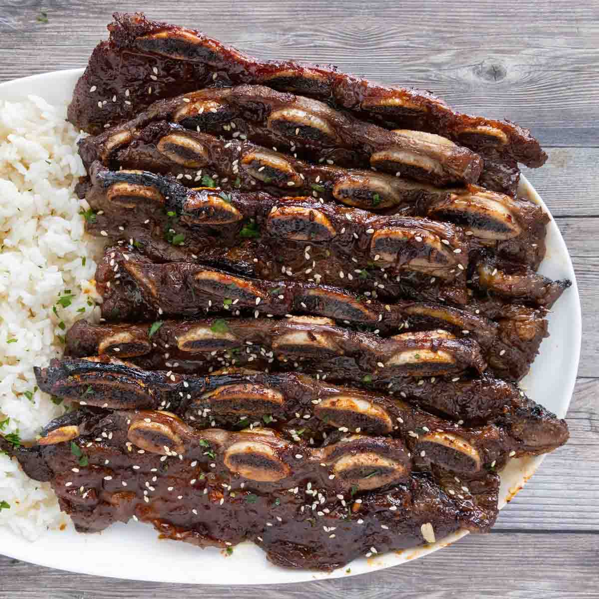 orean beef short ribs with rice on a white platter.